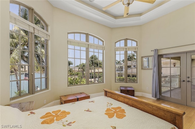 bedroom featuring french doors, multiple windows, ceiling fan, and hardwood / wood-style floors