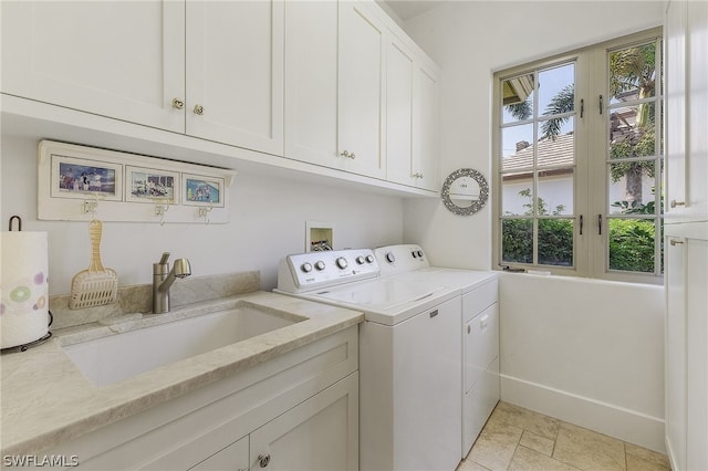 clothes washing area with sink, plenty of natural light, separate washer and dryer, and cabinets