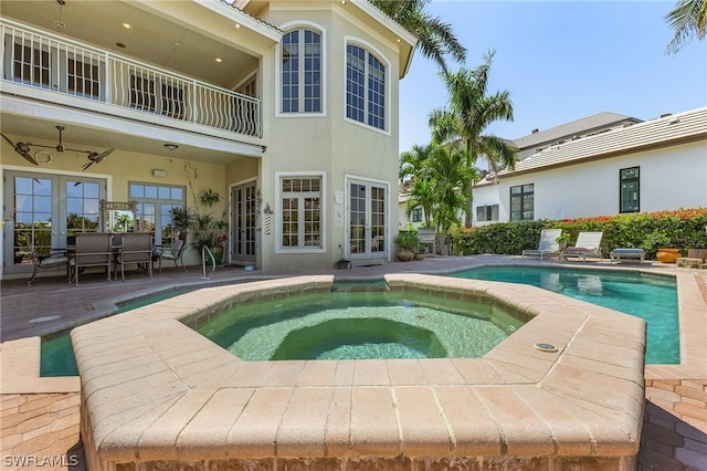 view of pool with a patio, french doors, an in ground hot tub, and ceiling fan