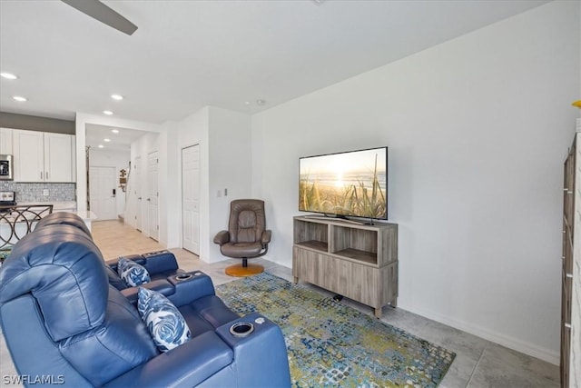 living room featuring baseboards, ceiling fan, and recessed lighting
