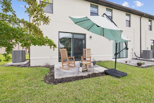 rear view of property with a yard, central AC unit, and a patio area