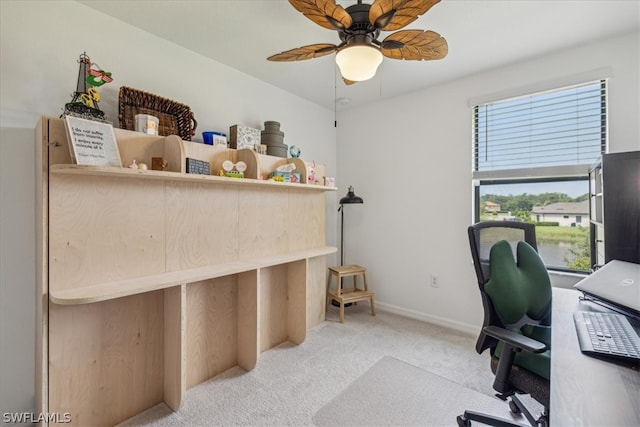 carpeted home office featuring ceiling fan