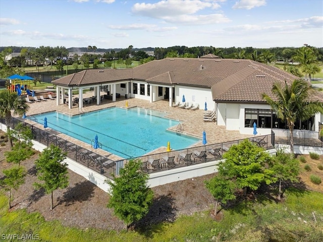 community pool with fence and a patio area