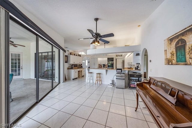 living room with ceiling fan and light tile patterned floors