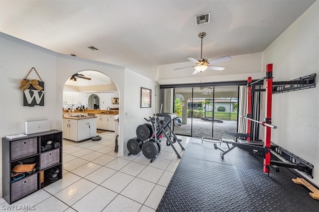 exercise area featuring ceiling fan, sink, and light tile patterned floors