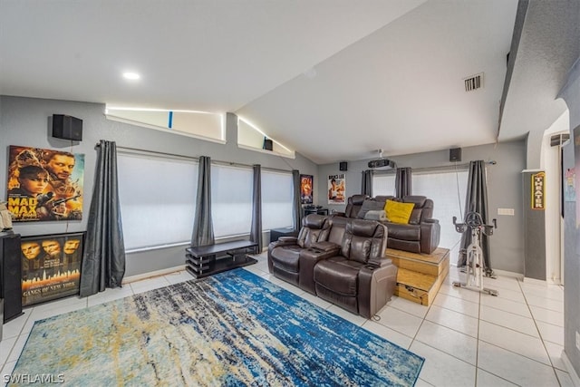 home theater featuring light tile patterned floors and vaulted ceiling