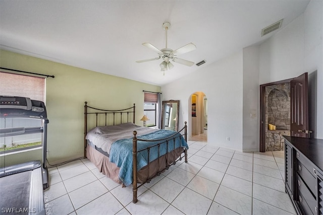 bedroom with ceiling fan, light tile patterned floors, ensuite bathroom, and lofted ceiling