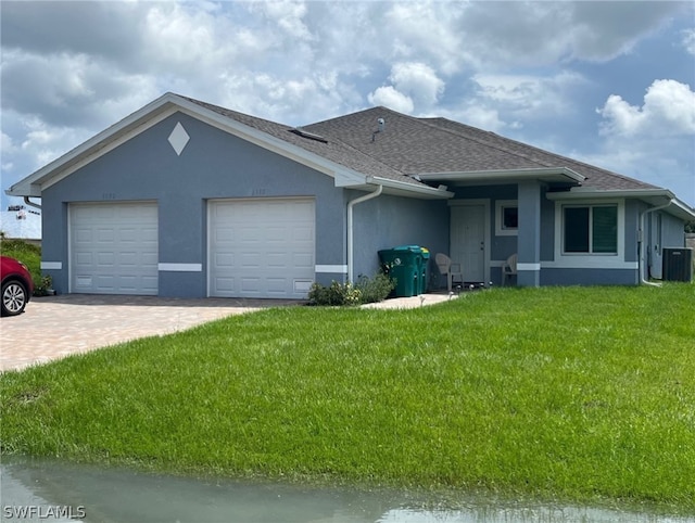 view of front of house with a garage, central AC, and a front lawn