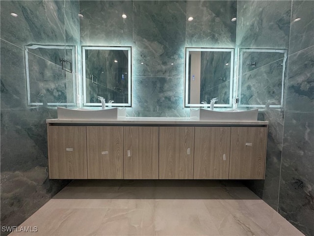 bathroom featuring vanity and tile walls