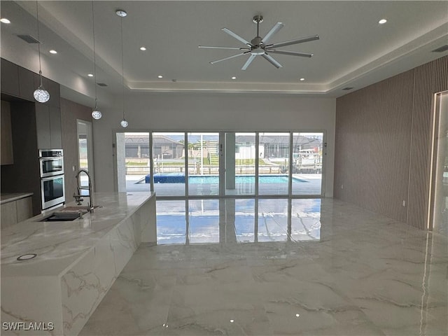 interior space featuring a raised ceiling and sink