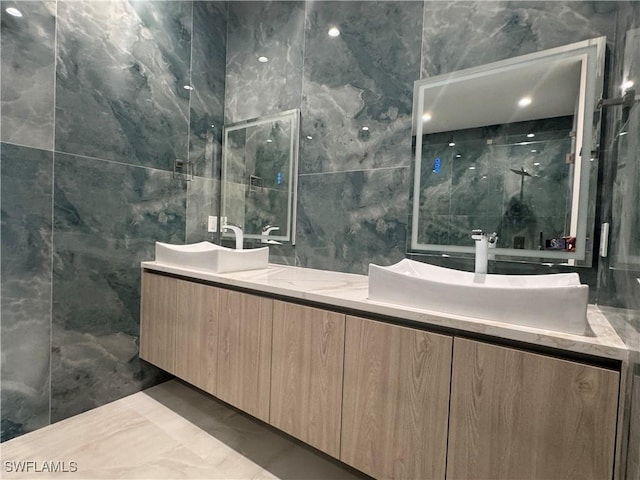 bathroom with vanity, tile walls, and walk in shower