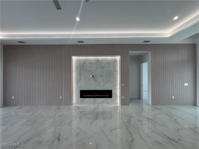 unfurnished living room featuring a fireplace and a raised ceiling