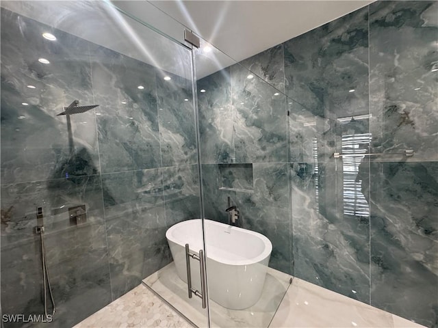 bathroom with tile walls and independent shower and bath