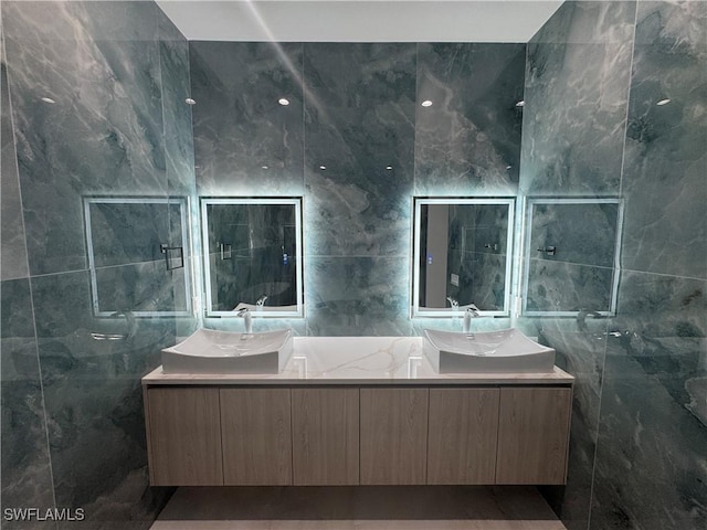 bathroom with vanity and tile walls