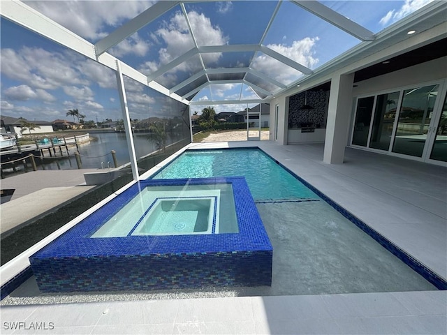 view of pool with a patio area, a water view, glass enclosure, and an in ground hot tub