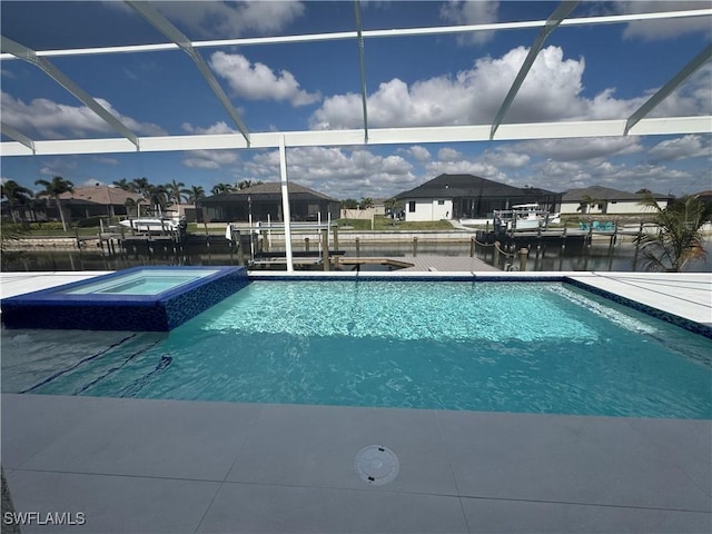 view of swimming pool with a lanai, an in ground hot tub, and a water view