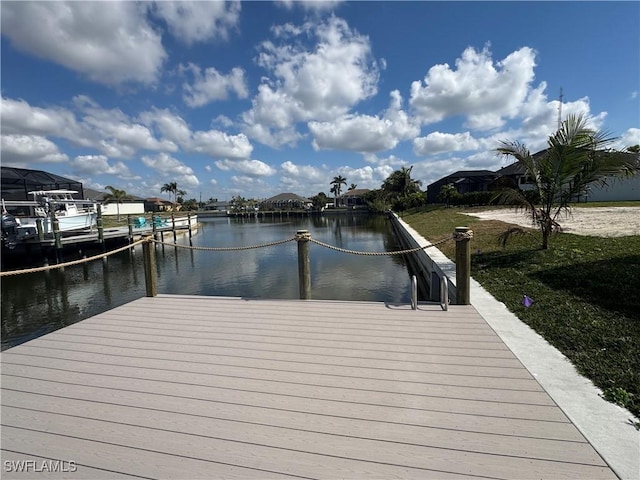 dock area featuring a water view and a lawn