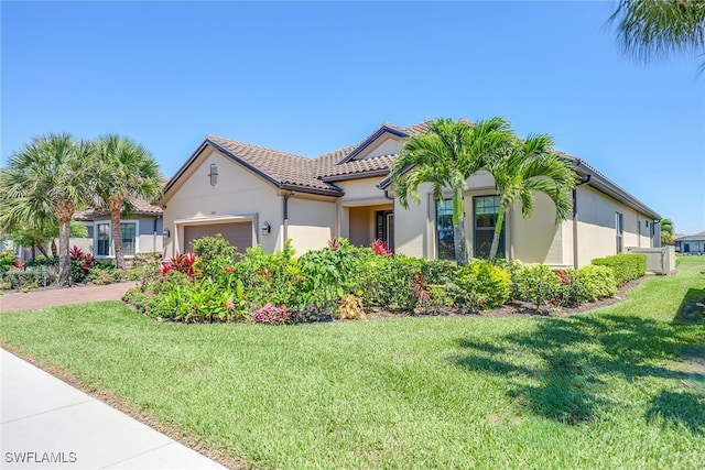 mediterranean / spanish home with a garage and a front lawn