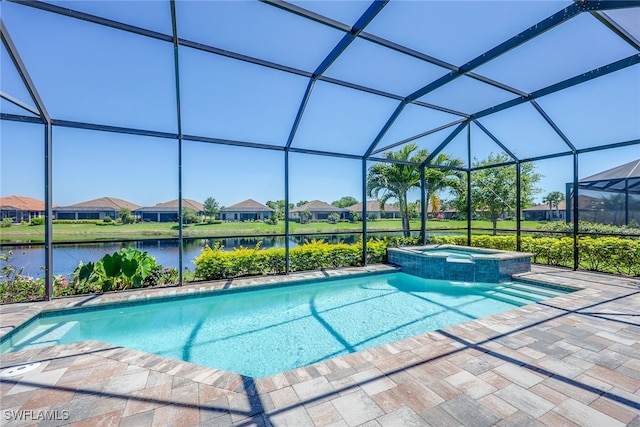 view of pool featuring glass enclosure, an in ground hot tub, a patio area, and a water view