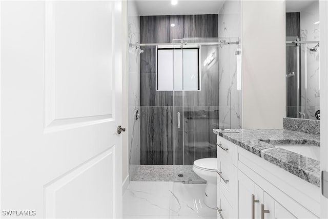 bathroom featuring toilet, a shower with shower door, and vanity