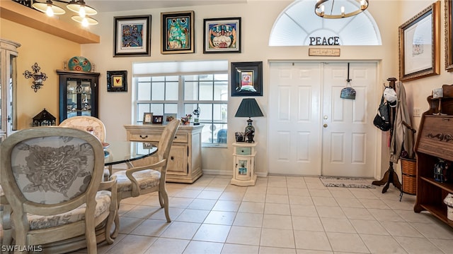 entryway with light tile patterned flooring and a chandelier