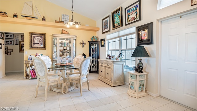 tiled dining space featuring high vaulted ceiling