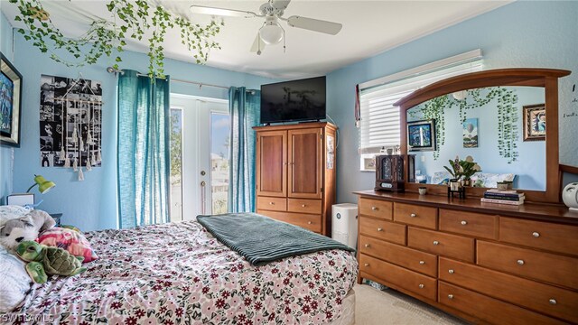 bedroom with light colored carpet, access to outside, and ceiling fan