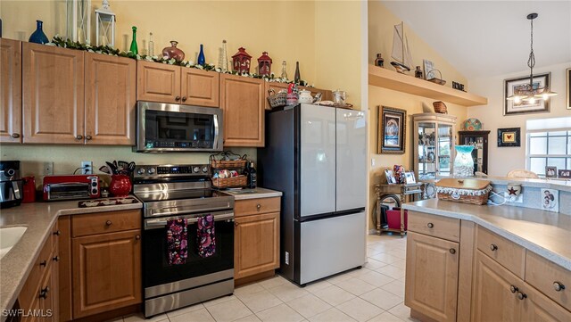 kitchen with light tile patterned floors, stainless steel appliances, hanging light fixtures, and vaulted ceiling