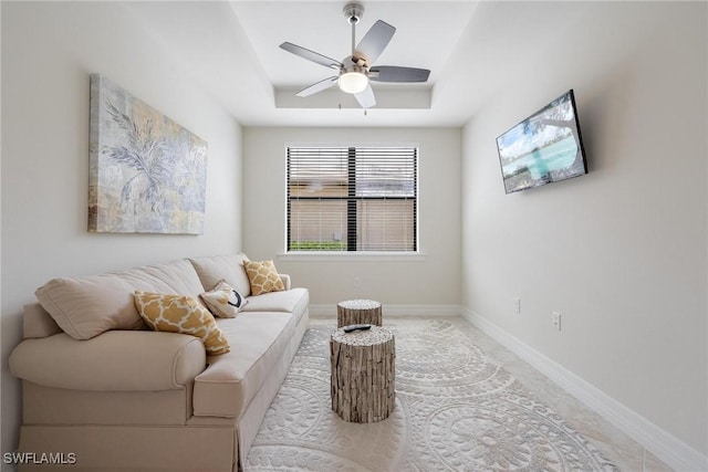 sitting room with a tray ceiling and ceiling fan