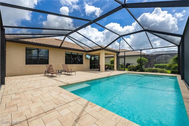 view of swimming pool featuring glass enclosure and a patio area