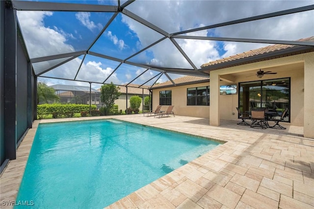 view of swimming pool featuring ceiling fan, a lanai, and a patio