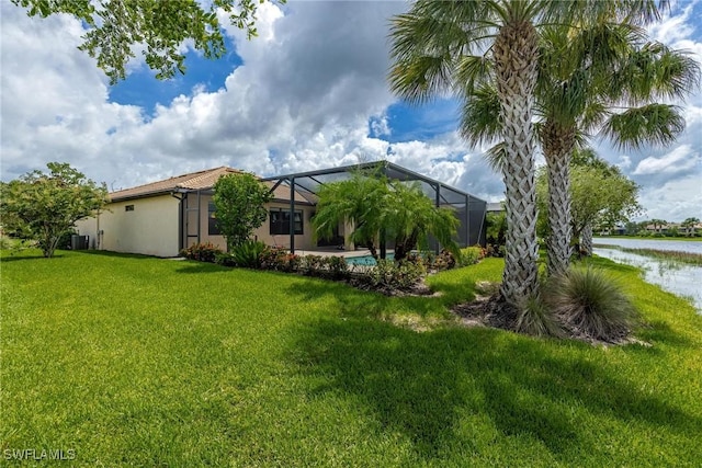 view of yard featuring a lanai, a water view, and central AC