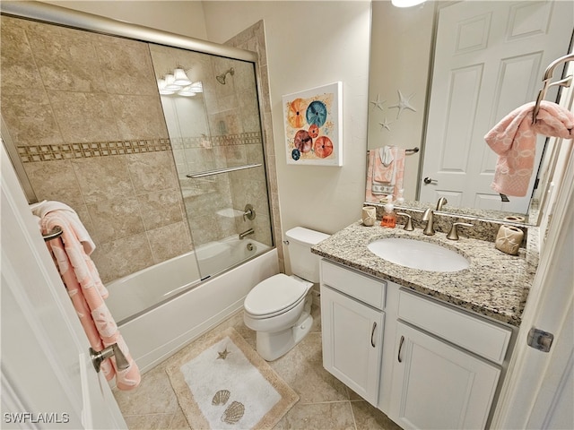 full bathroom featuring tile patterned flooring, vanity, toilet, and bath / shower combo with glass door