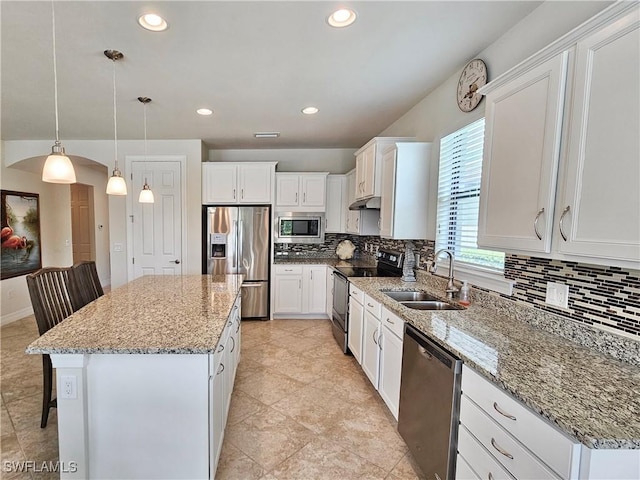 kitchen featuring appliances with stainless steel finishes, a kitchen island, pendant lighting, and sink