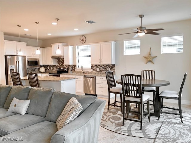 kitchen featuring white cabinetry, a healthy amount of sunlight, pendant lighting, and appliances with stainless steel finishes