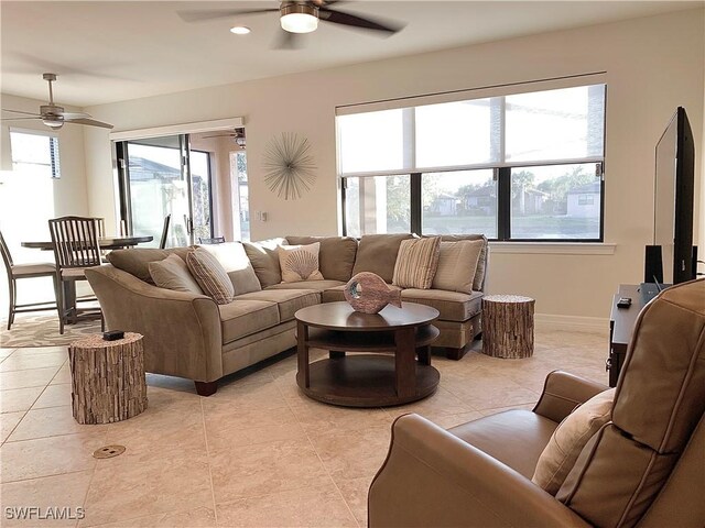 living room with light tile patterned floors, a wealth of natural light, and ceiling fan