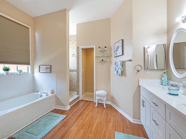 bathroom featuring vanity, plus walk in shower, and hardwood / wood-style flooring