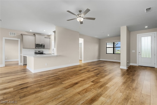 unfurnished living room with baseboards, recessed lighting, visible vents, and light wood-style floors