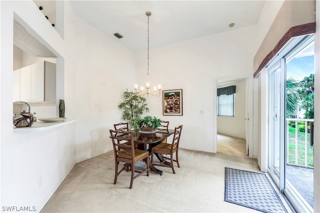 dining area featuring plenty of natural light, high vaulted ceiling, light carpet, and a chandelier