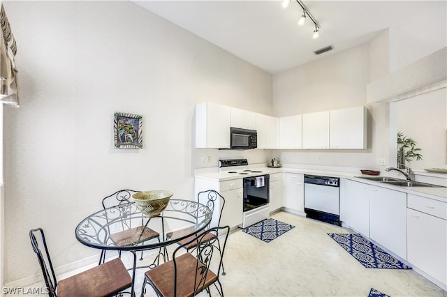 kitchen featuring white appliances, white cabinets, sink, track lighting, and light tile floors