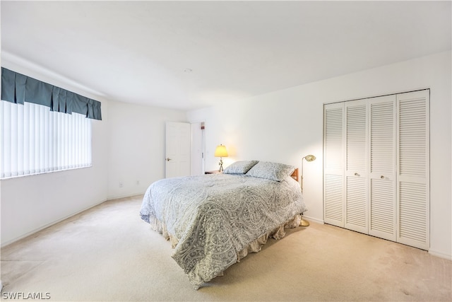 bedroom with a closet and light carpet