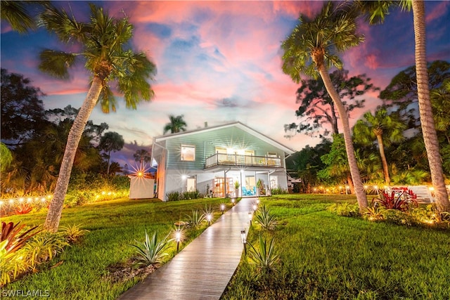 view of front of property with a balcony and a yard