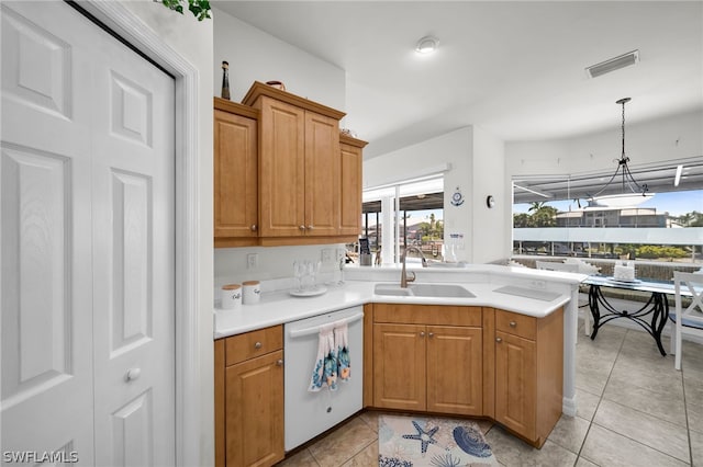 kitchen with hanging light fixtures, kitchen peninsula, sink, light tile flooring, and dishwasher