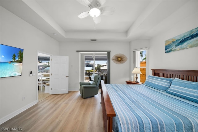 bedroom with multiple windows, light hardwood / wood-style floors, ceiling fan, and access to outside