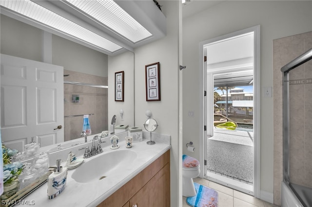 full bathroom featuring tile floors, bath / shower combo with glass door, toilet, and vanity