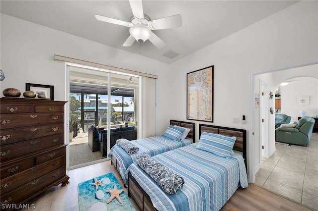 bedroom featuring light tile flooring, ceiling fan, and access to exterior