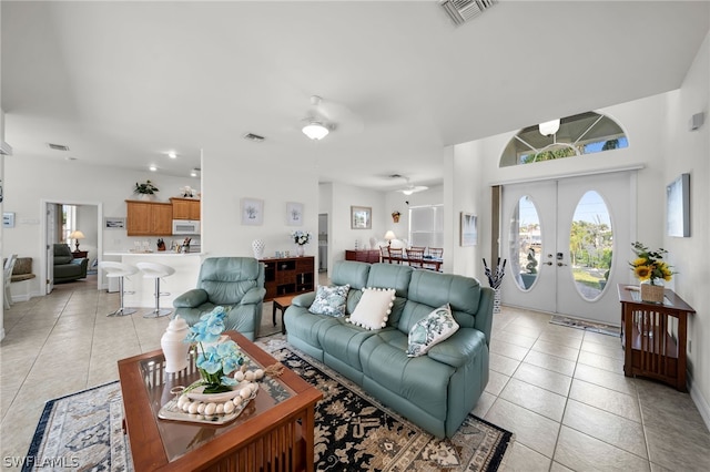 living room featuring ceiling fan, french doors, and light tile floors