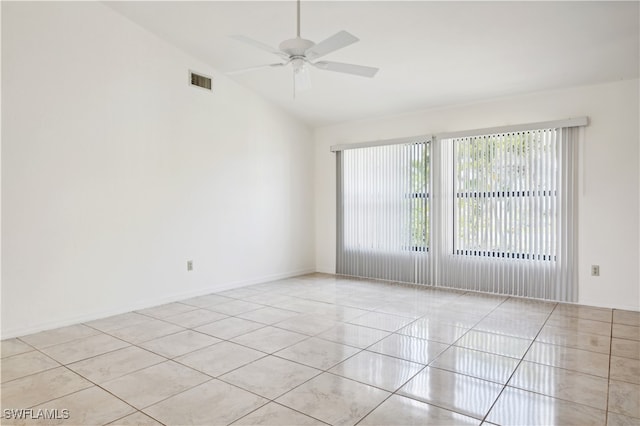 empty room featuring ceiling fan, vaulted ceiling, and light tile patterned floors