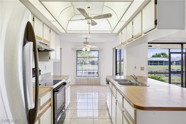 kitchen featuring ceiling fan, black electric range oven, light tile patterned floors, sink, and stainless steel fridge