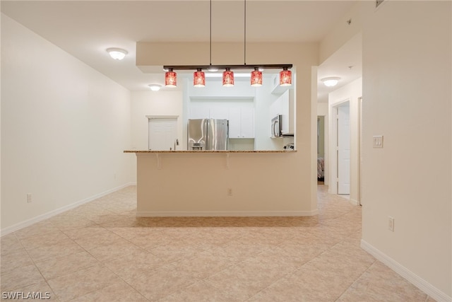 kitchen featuring a kitchen breakfast bar, appliances with stainless steel finishes, white cabinets, decorative light fixtures, and light tile floors